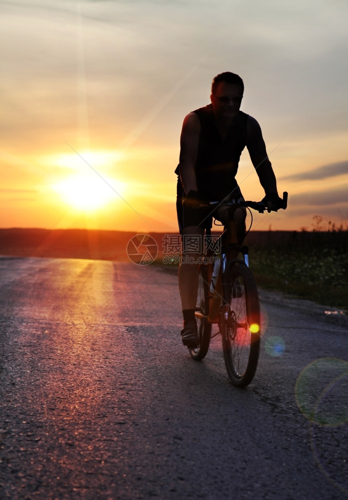成功努力骑自行车的人日落时骑自行车在野外停留的旅客图片