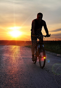 成功努力骑自行车的人日落时骑自行车在野外停留的旅客图片