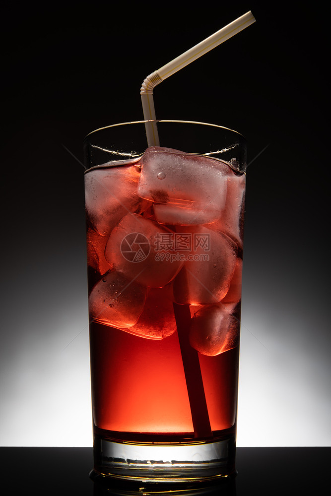 夏天饮料与红色鸡尾酒和冰立方体隔离的玻璃与红色鸡尾酒和冰立方体隔离的玻璃目图片
