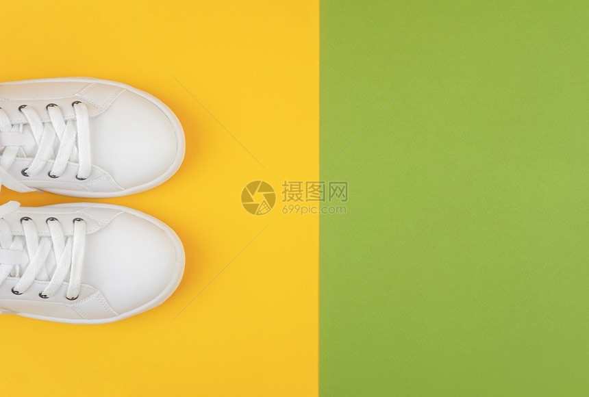 娱乐脚丫子速度白色运动鞋绿和黄背景鞋带的运动生活方式概念顶视图平躺复制空间白色运动鞋绿和黄背景鞋带运动图片