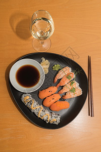 寿司饭和白红酒在桌上请享用美餐生姜虾一种背景图片