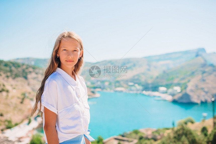 山边美丽的岩石和海边可爱女孩看着巴拉克瓦的小姑娘在山顶上享受谷风景的峡天空游客旅行图片
