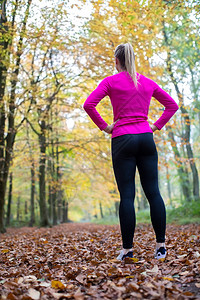 自然锻炼后通过林地休息的秋季天春晨初妇女回观赛跑者后部图片