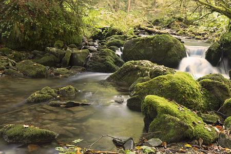 在绿色石块间流动的瀑布高清图片