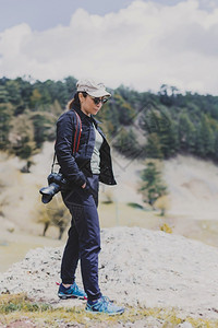 漫步在山间的女摄影师冒险徒步旅行顶峰图片