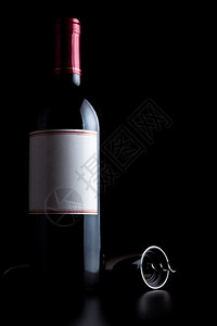 精神白色的标签红葡萄酒瓶和黑漆上隔绝的软木炉图片