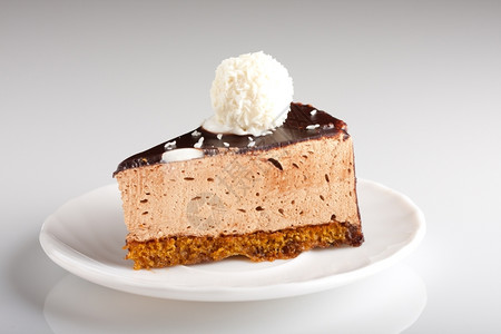 馅饼生日胖的盘子上美味巧克力蛋糕白色背景的浅焦点图片