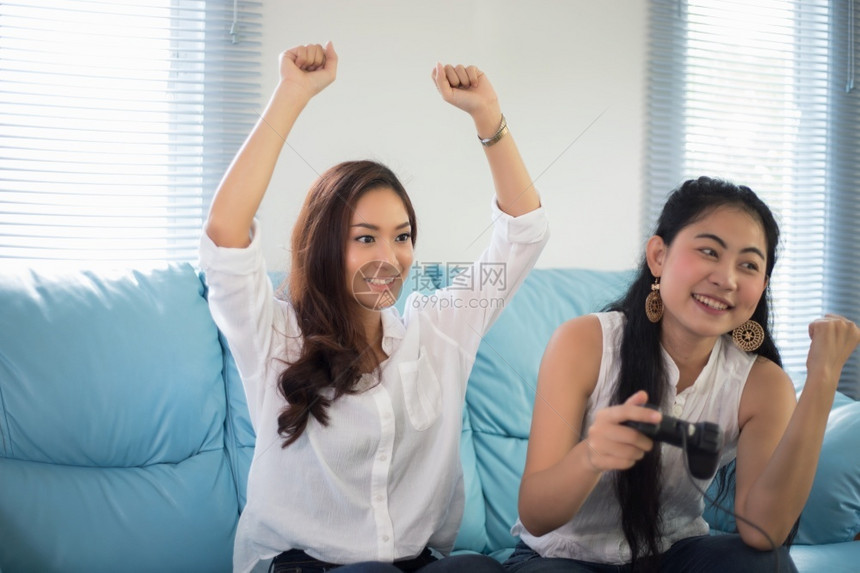 电话游戏玩家两个亚洲女竞争对手朋友玩电子游戏在家开心快乐地欢欣喜图片