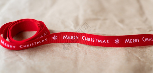 横幅红丝带在工艺纸上铺开圣诞快乐字样刻问候材料图片