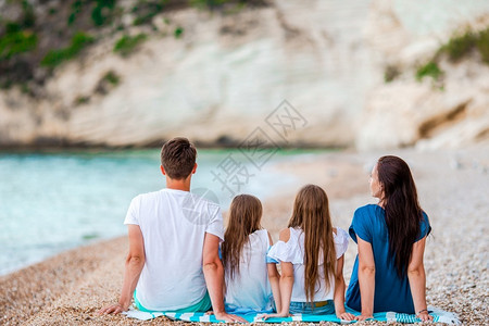 渡假的年轻家人在海边幸福的家庭一起过着快乐愉的时光婴儿玩女图片