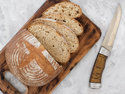 餐桌上新鲜烤面包边上刀子旁的面包是切片粉自然最佳图片