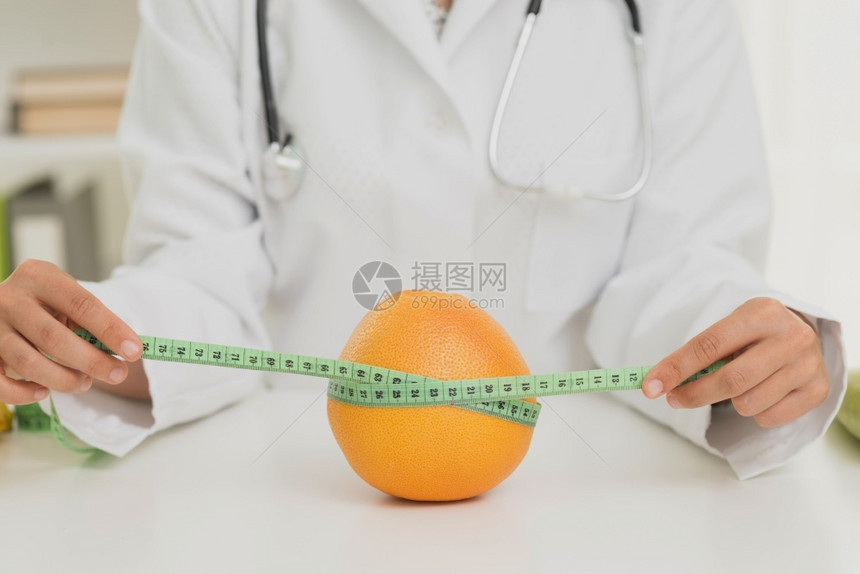 苗条的近身营养学家测量橙色新鲜的活图片