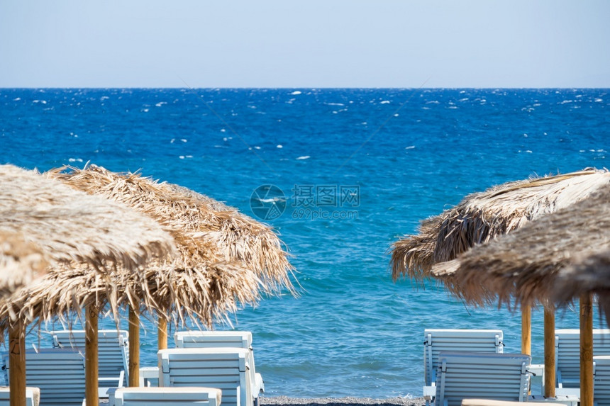 桑托里尼带雨伞和甲板椅的海滩滨日光浴床希腊语图片