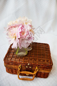 粉红牡丹花的一束非常美丽粉红花束瓶里装着一束粉红色的花朵放在一个木箱子上美丽配成一束很漂亮的花瓶里装着粉红色的花皮包背景