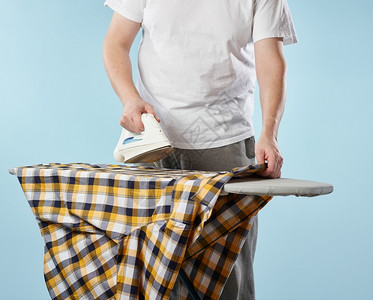 家务一个男人烫衣板上一身钢铁和格斗衬衫浅蓝色背景男装图片