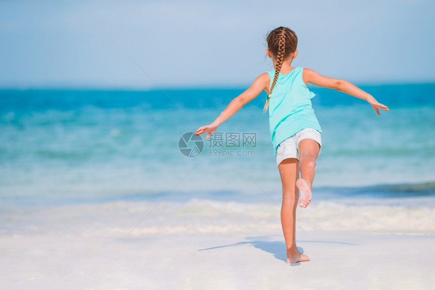 愉快步行裙子在海滩上散步的小女孩和在海滩玩可爱的小姑娘在蜜蜂度假的时候在海滩上玩图片