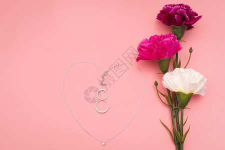 郁金香国际的邀请妇女节花朵和心形项链粉红背景的鲜花和心形项链图片