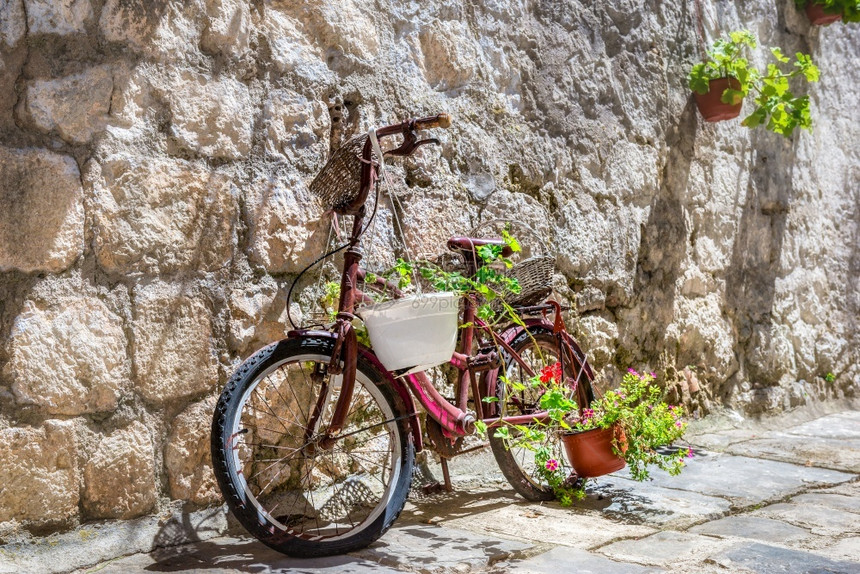 自行车在PerastBicycro老城街上配鲜花的自行车城市佩拉斯特循环图片
