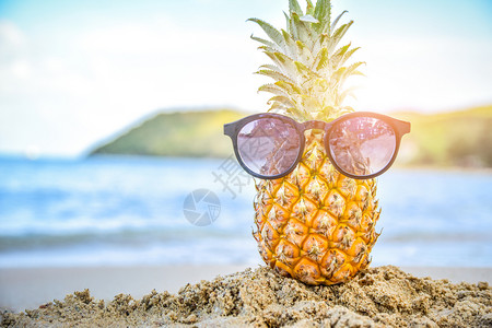 健康配饰眼镜太阳玻璃在菠萝上海滩景背夏天假期概念图片