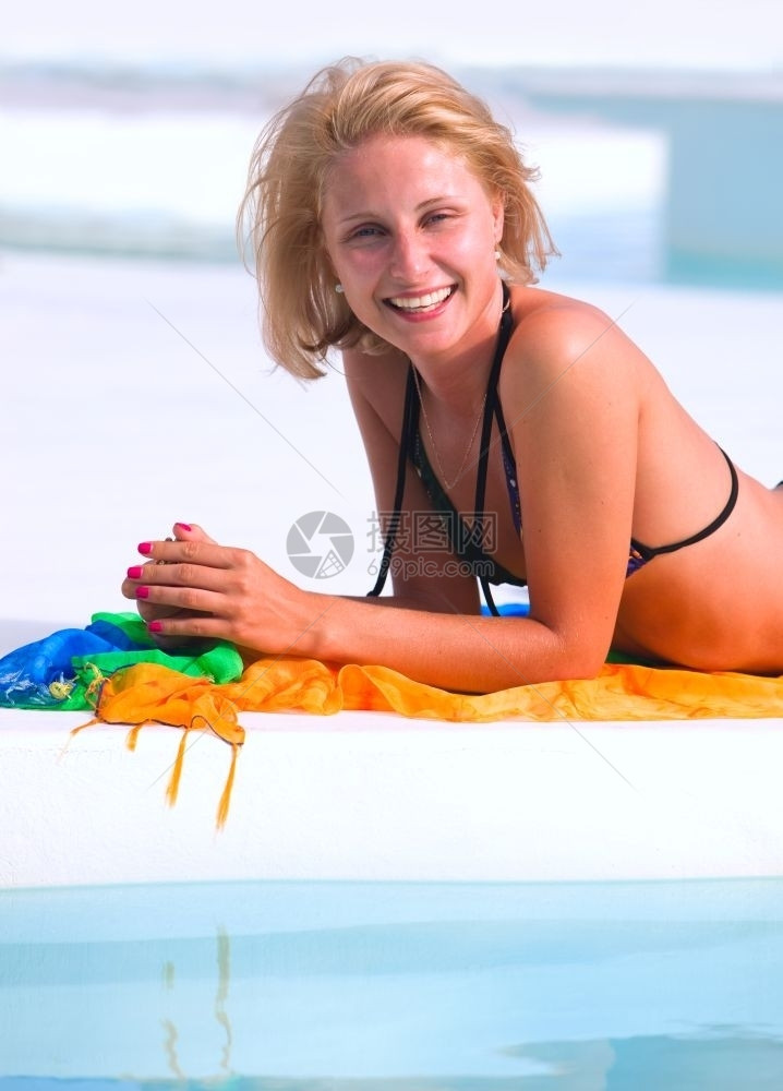 泳装棕褐色健康游泳池里的年轻女子图片