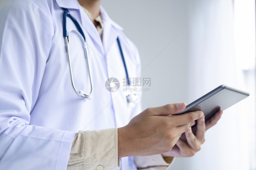 医生在工作时使用平板电脑图片