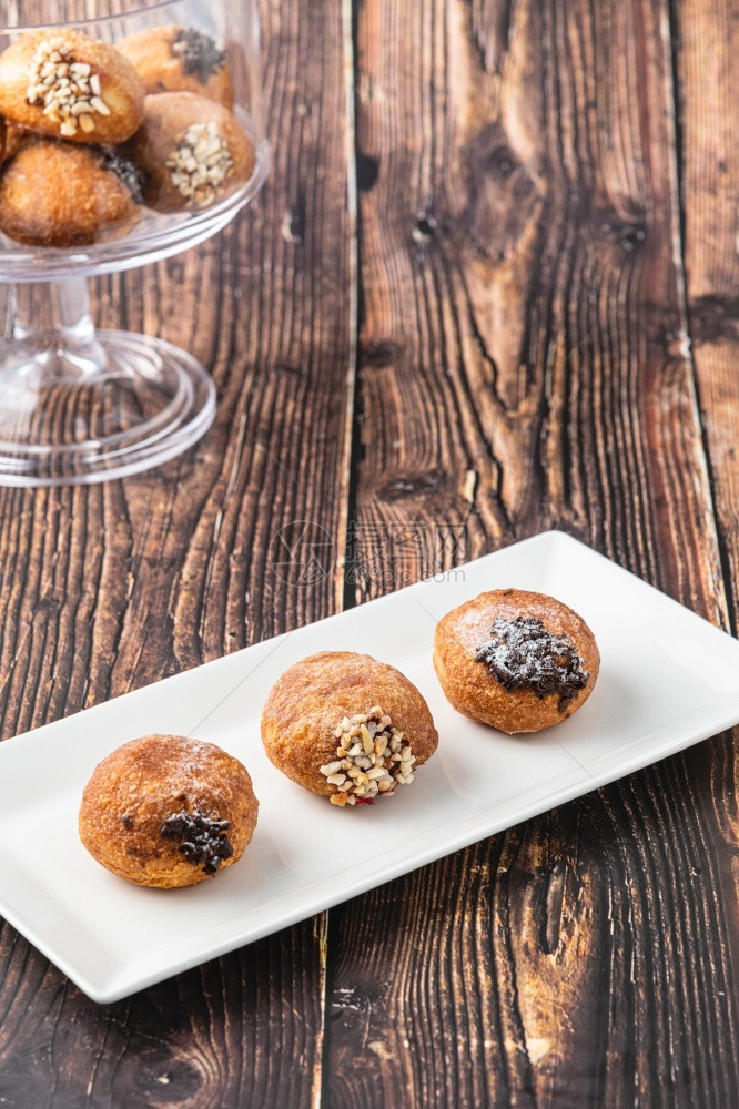 烘烤的Bombolone或bomboloni是意大利填满甜圈和零食的意大利品德国甜圈克拉芬或贝林机装满果酱和巧克力刨冰不良图片