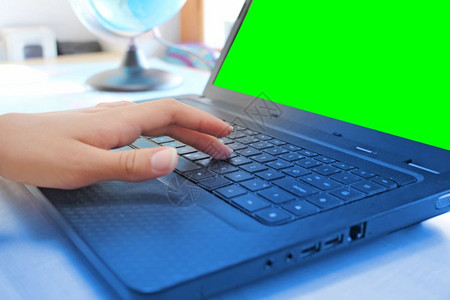 妇女在办公室用笔记本电脑工作时手握绿色屏幕按钮进入桌子图片