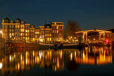 荷兰阿姆斯特丹市风景晚上在荷兰阿姆斯特尔河上黄昏建筑的交通图片