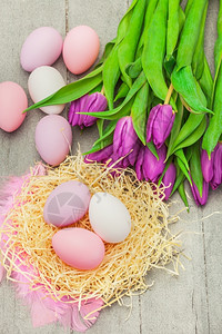 展示春天以东鸡蛋和木制桌边紫色郁金香食物图片