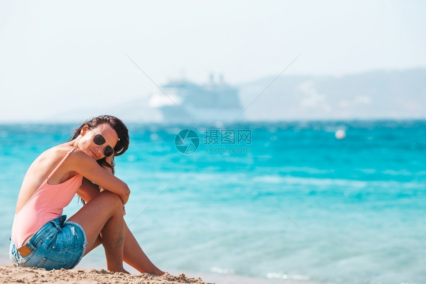 户外支撑游客欧洲海滩上穿泳衣的年轻女子热带暑假期间在海滩上度过的年轻美丽女子图片