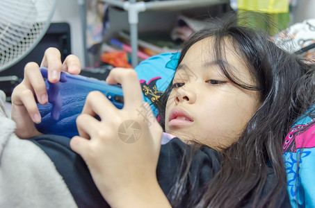 互联网房间视频一个亚洲女孩了躺在床的手机游戏中图片