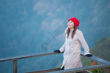 年轻的美丽站在悬崖边年轻女子俯视山上雾泰国有图片
