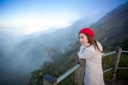 站在悬崖边的年轻女子俯视山上雾泰国人们土地图片