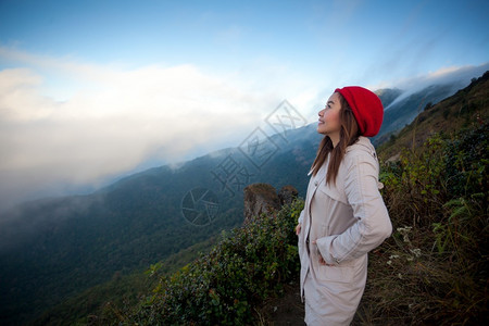 因他农云站在悬崖边的年轻女子俯视山上雾泰国旅行图片