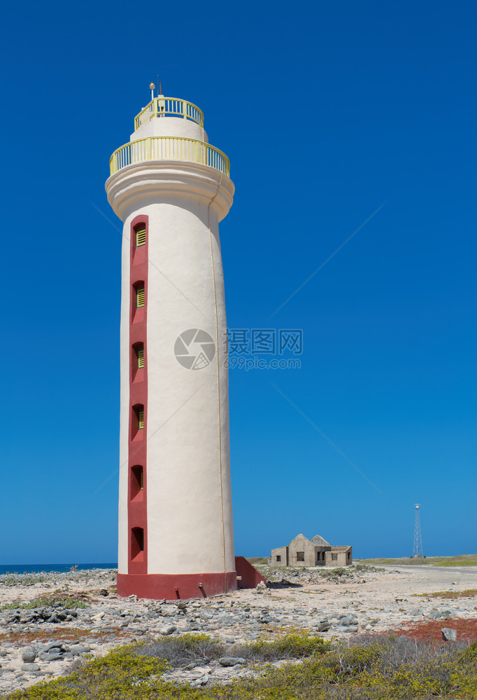海滨蓝色的博内尔岛海岸废墟的白灯塔警告图片