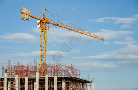 住宅黄塔起重机和正在建筑中的以蓝天空工业概念为参照建造地背景筑地点背景