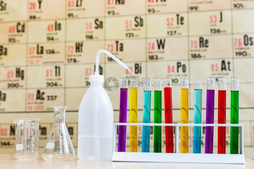 在挂图前配有彩色测试管和玻璃的化学以显示周期表化学家丰富多彩的紫色图片