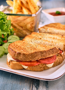 托斯特烤面包加土豆香肠芝士番茄和生菜在白盘上供应小吃开胃菜图片