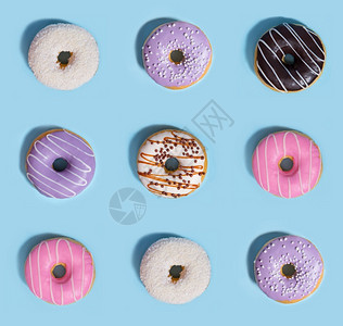 糖粉色的丰富多彩蓝桌背景九个多彩甜圈九色的图片