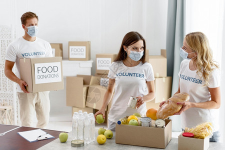 服务人们志愿员帮助提供食品捐赠援助纸盒图片