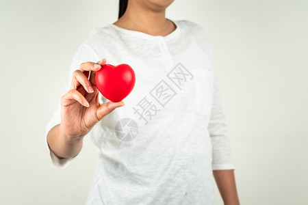 情人节年轻的快乐世界心脏日年轻女握着红心手的概念图片
