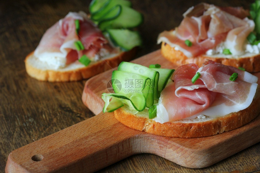 传统的意大利开胃菜用烤面包和芝士黄瓜蛋白饼来烤面包传统的意大利式开胃菜用干酪黄瓜和青豆来烤面包肉木制的奶油图片