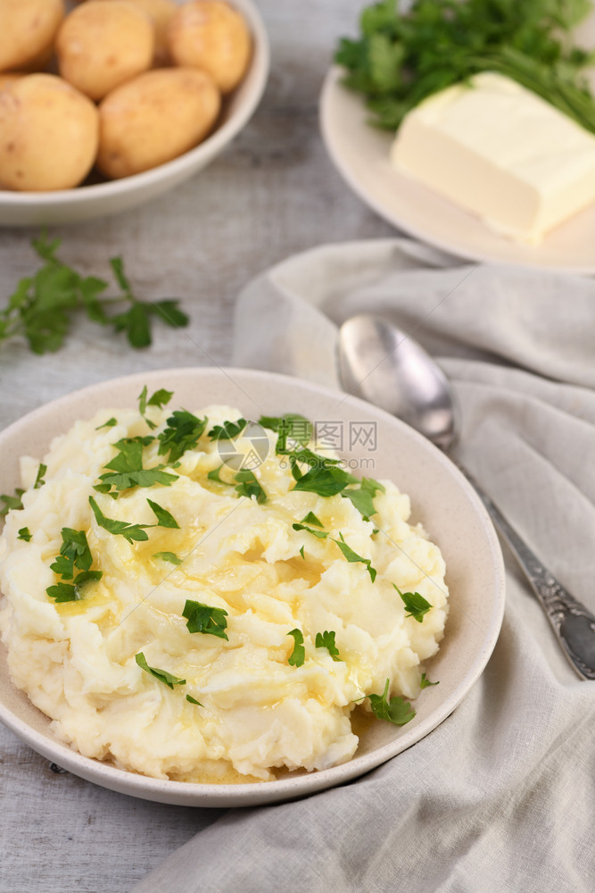 一盘土豆泥用融化的黄油浇满了马铃薯泥用青菜填满爽朗食物健康图片