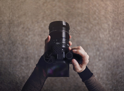 肖像镜头专业的使用相机拍摄照片黑暗色调POV或低角选择焦点图像屏幕的顶视年轻摄影师女背景图片