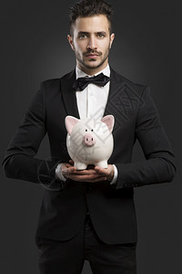 穿礼服的人拿着猪钱盒行政人员快乐的专业图片