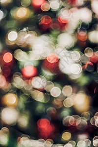 劳动节彩旗装饰前夕装饰风格红色的圣诞节树上抽象颜色模糊装饰球和光线字符串带有bokeh浅背景冬假季节背景