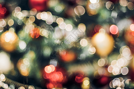 圣诞彩旗背景冬天卡片圣诞节树上的抽象颜色模糊装饰球和光线字符串带有bokeh浅背景冬假季节金子背景