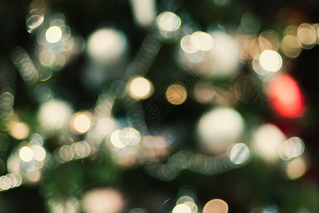 圣诞彩旗散景圣诞节树上的抽象颜色模糊装饰球和光线字符串带有bokeh浅背景冬假季节十二月装饰品背景