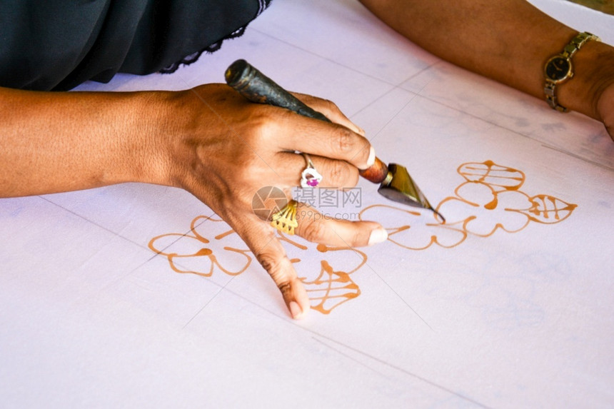 在布料上涂水彩色以制造BatikMakeBatik油漆传统电棍工人老的画图片