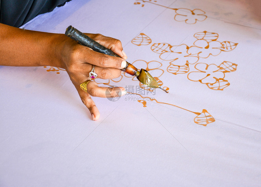 在布料上涂水彩色以制造BatikMakeBatik油漆传统电棍绘画蜡染工作图片